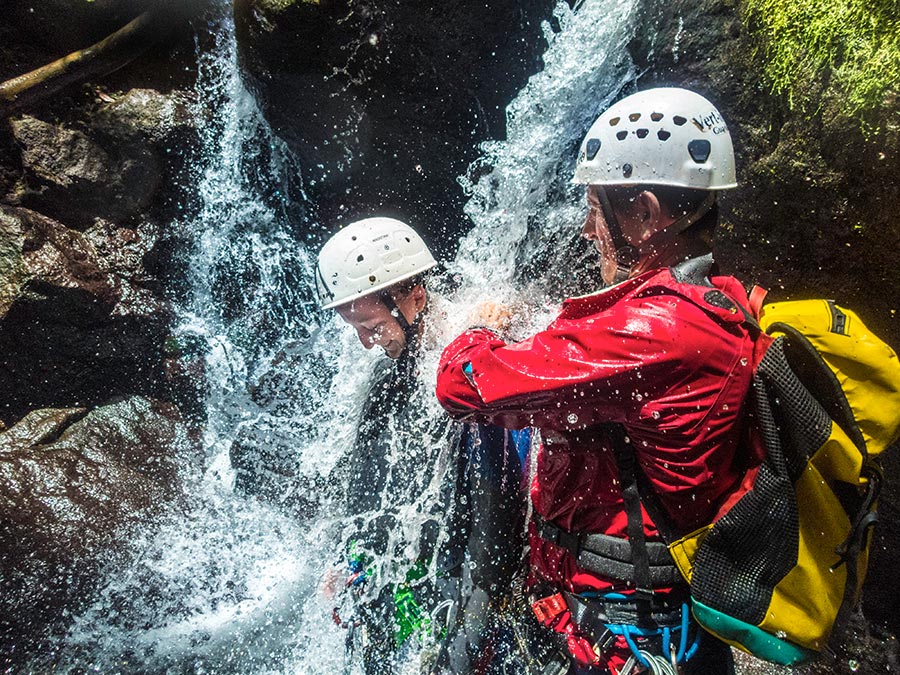 Pratiquants de canyoning sous une cascade en forêt tropicale en Basse-Terre, Guadeloupe