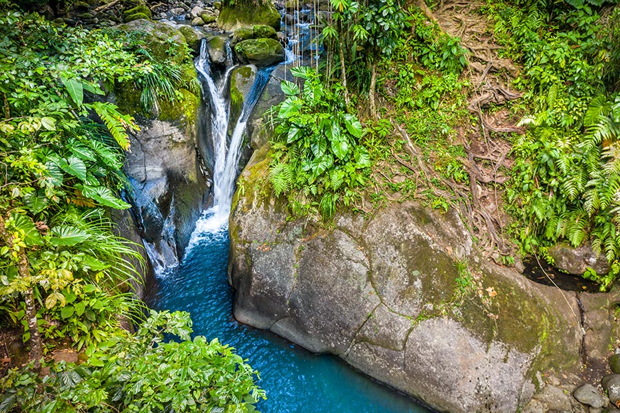 Cascade entourée de végétation tropicale et bassin d’eau turquoise à Gourbeyre en Basse-Terre, Guadeloupe