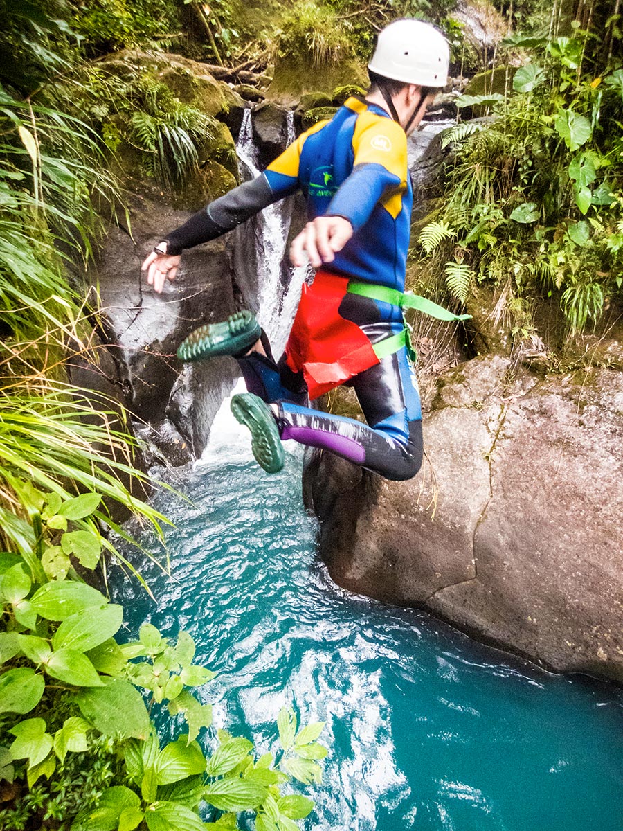 Personne sautant dans une eau turquoise lors d’une sortie canyoning en Basse-Terre, Guadeloupe